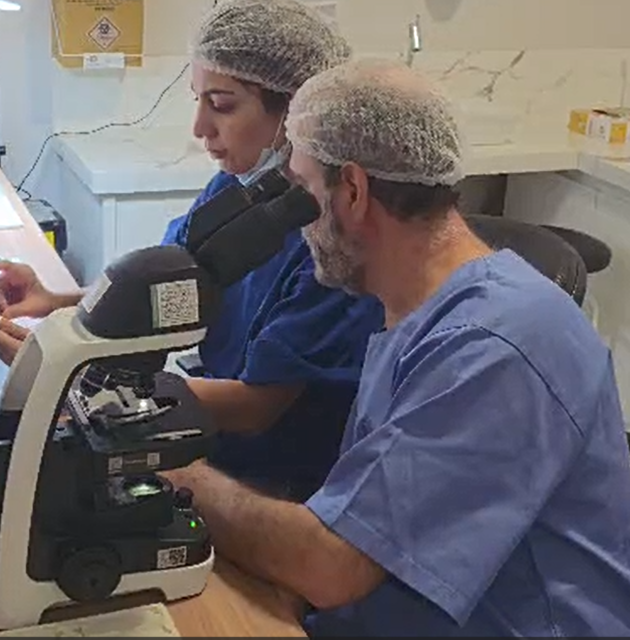 Equipe avaliando lâminas no microscópio